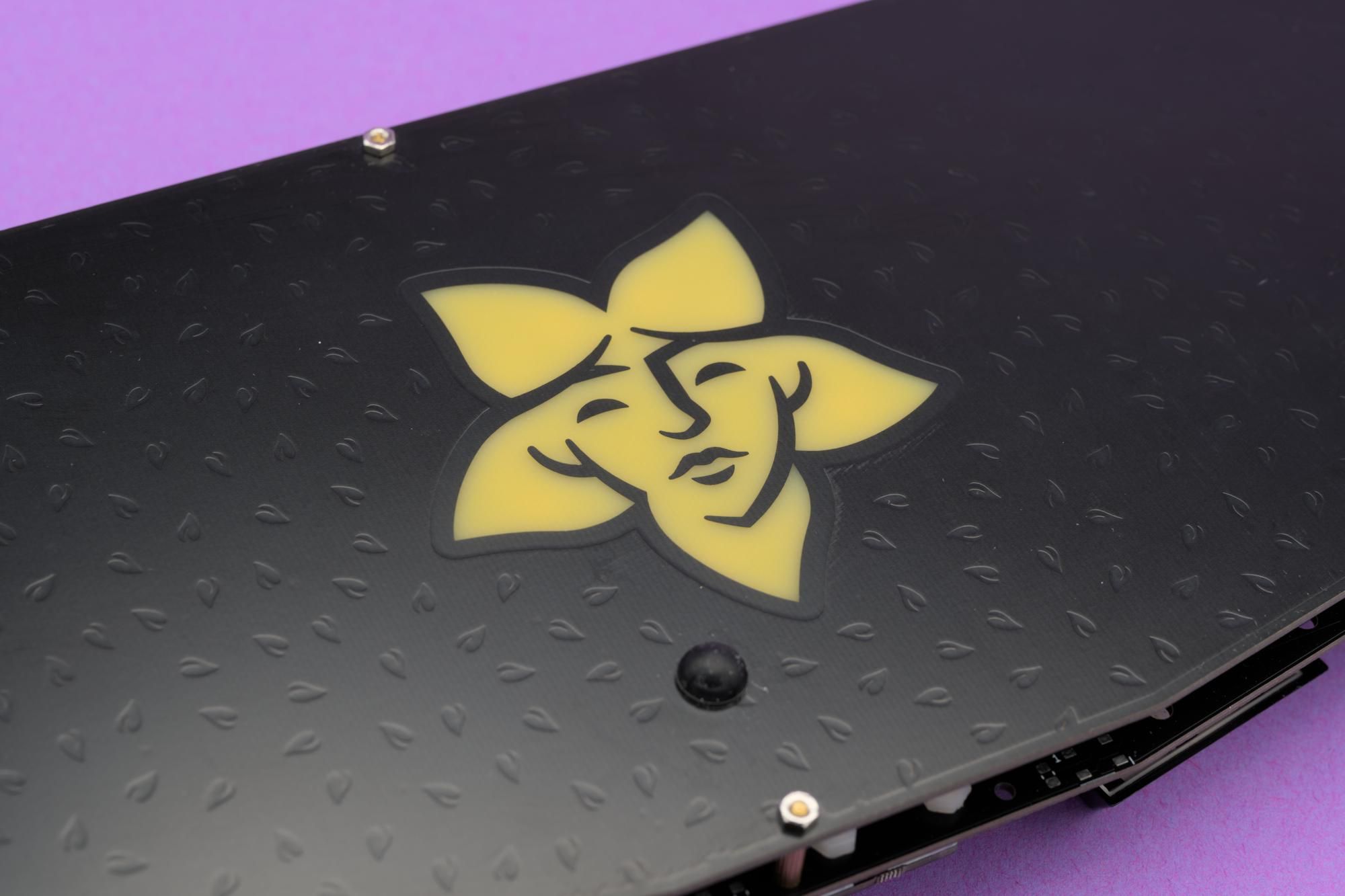 Detail shot of the bottom of the keyboard showing the engraved detail of leaves and the semitransparent logo.