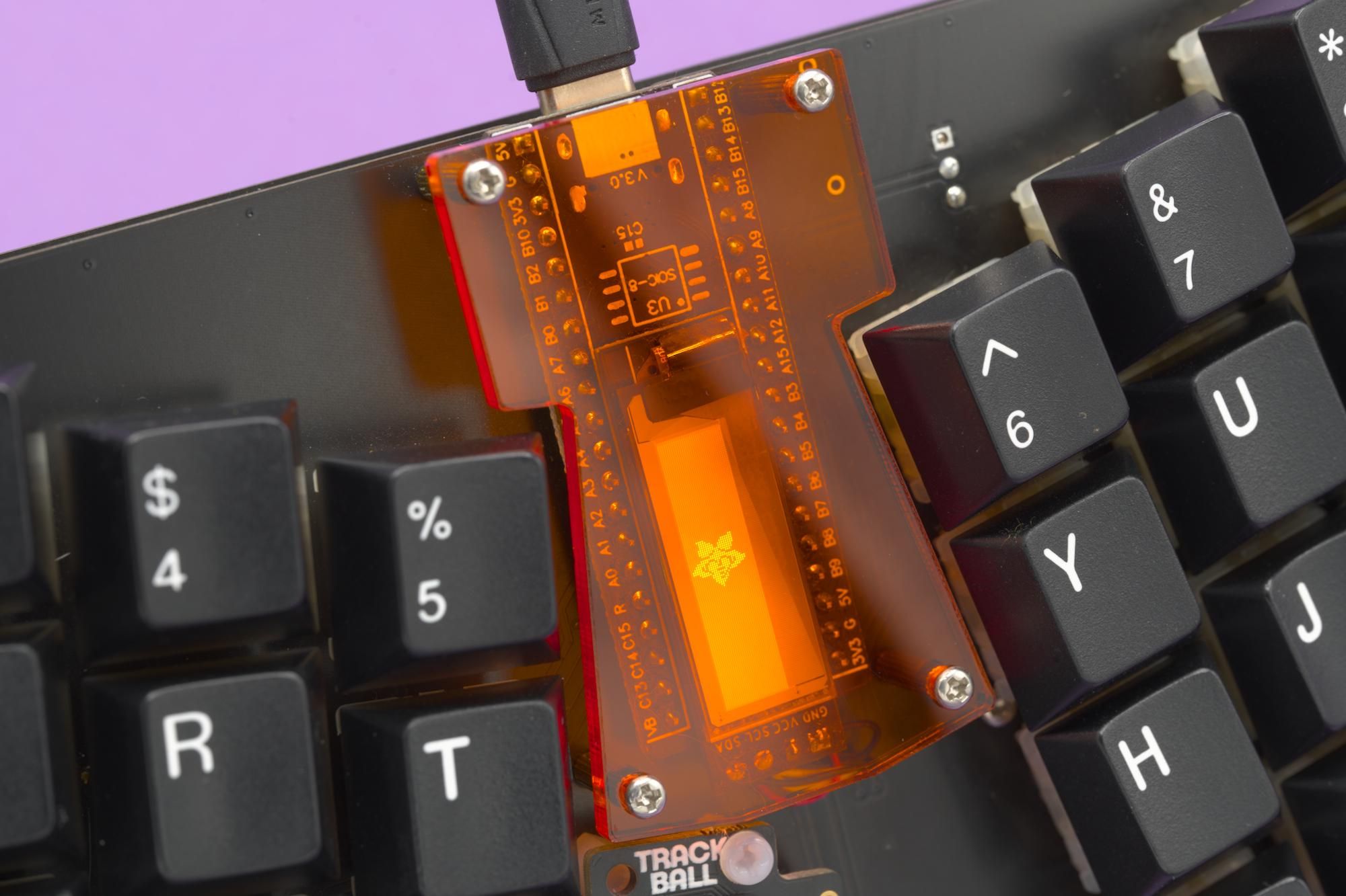 Close-up shot of the OLED display with a transparent orange cover.