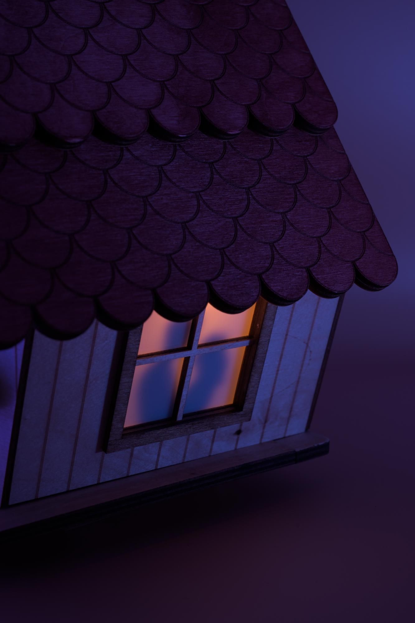 Illuminated window on the side with silhouette of man and woman couple